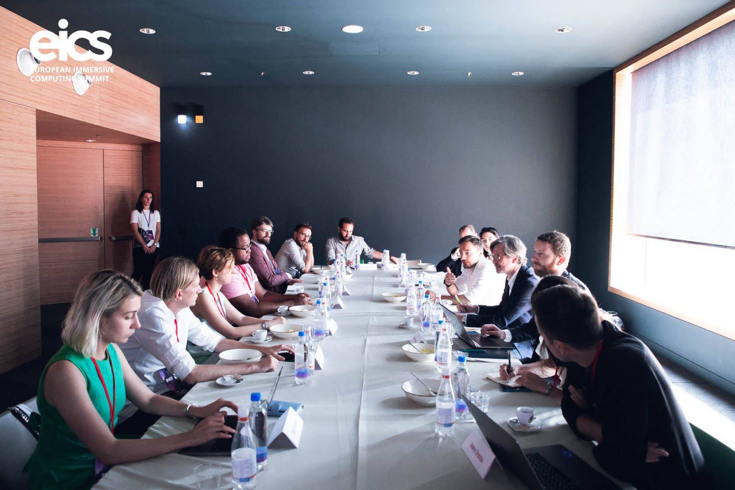Attendees sit around a long table during an EICS meeting.