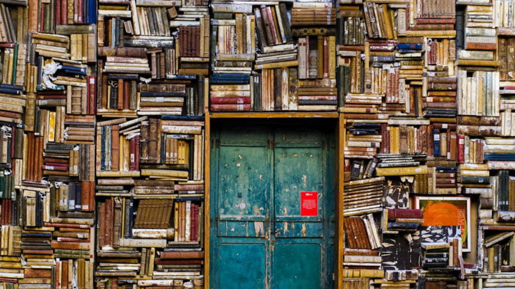 A doorway surrounded by densely stacked books.